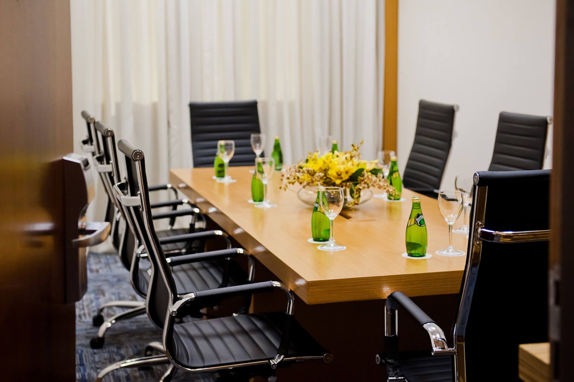 Uma sala de conferências com uma longa mesa de madeira e cadeiras.