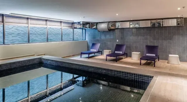 Uma grande piscina coberta com cadeiras ao redor.