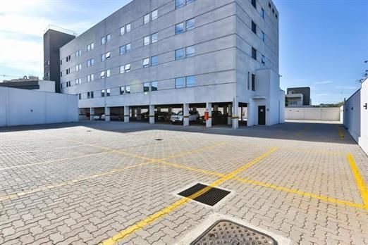 Um grande edifício com um estacionamento na frente
