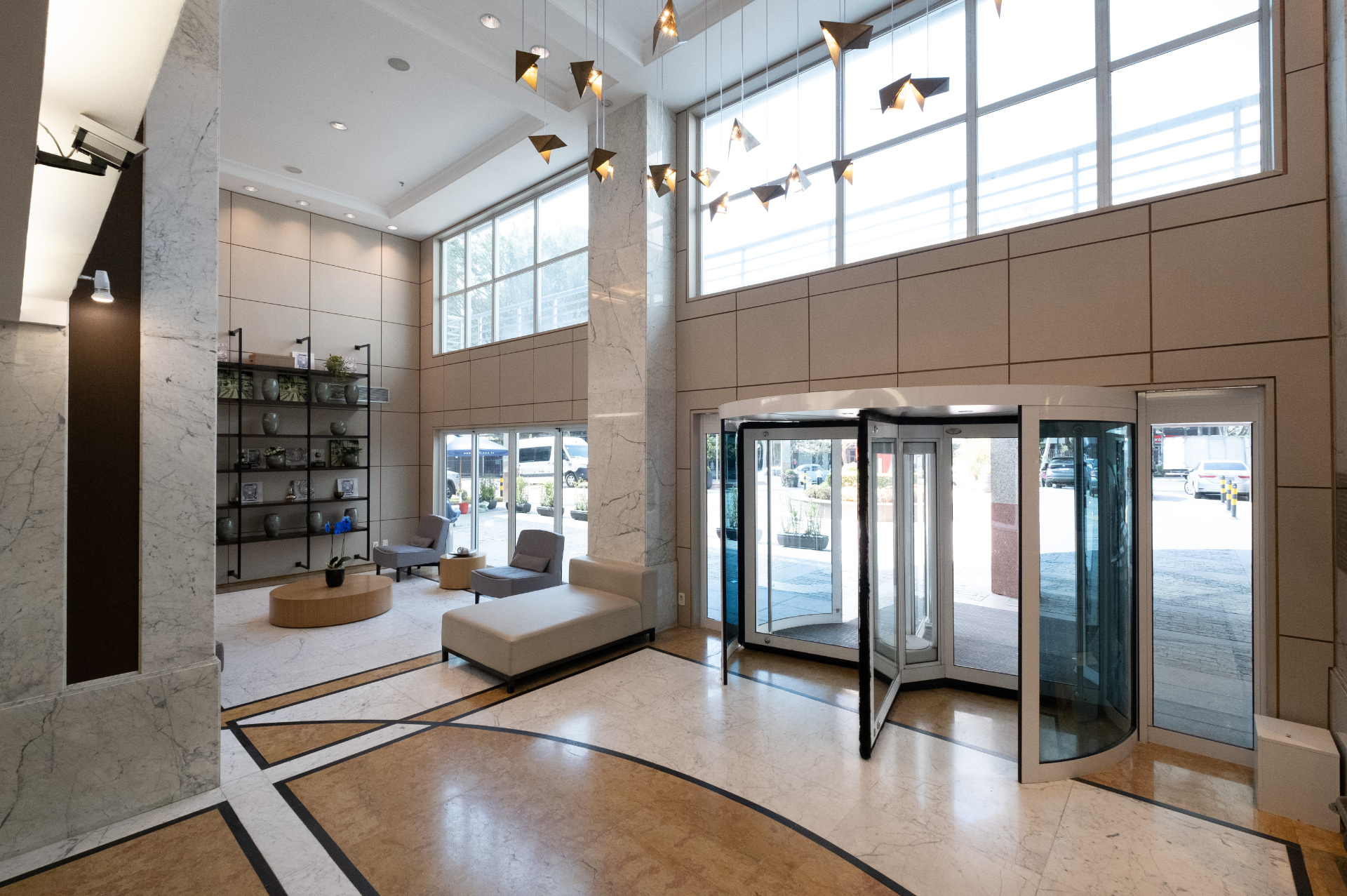 Um grande lobby com uma porta giratória e muitas janelas