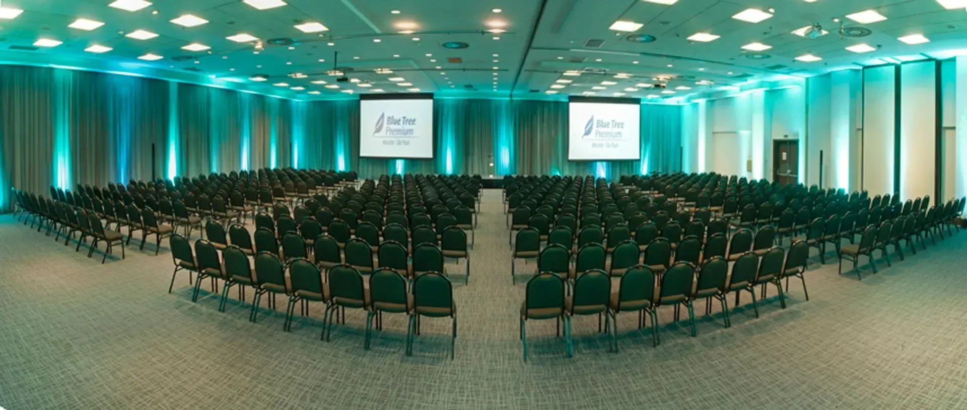Uma sala de conferências com uma longa mesa de madeira e cadeiras.