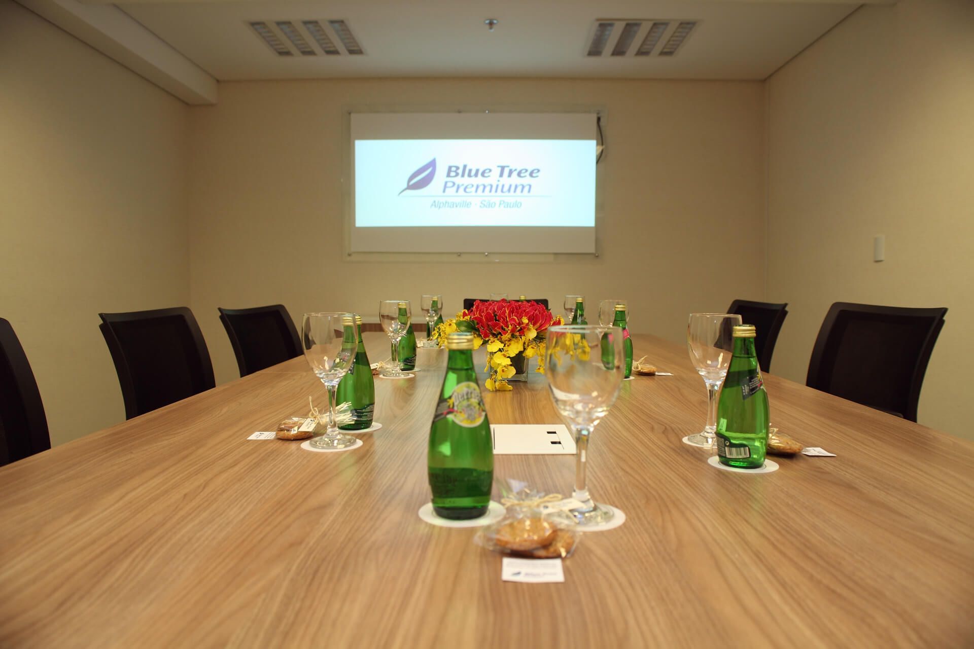 Uma sala de conferências com uma tela de projetor que diz blue tree premium