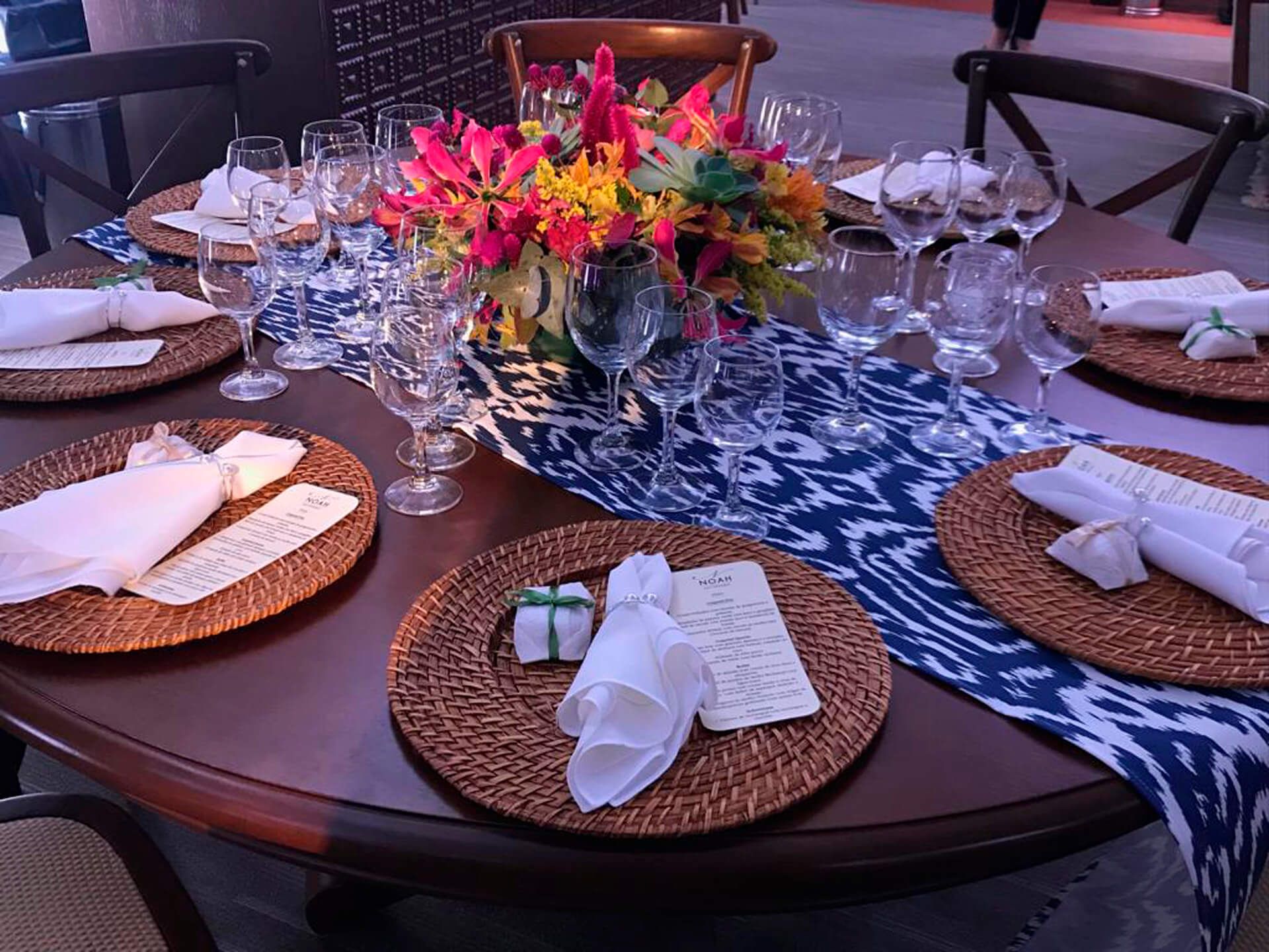 Uma mesa com pratos, guardanapos, copos e flores sobre ela