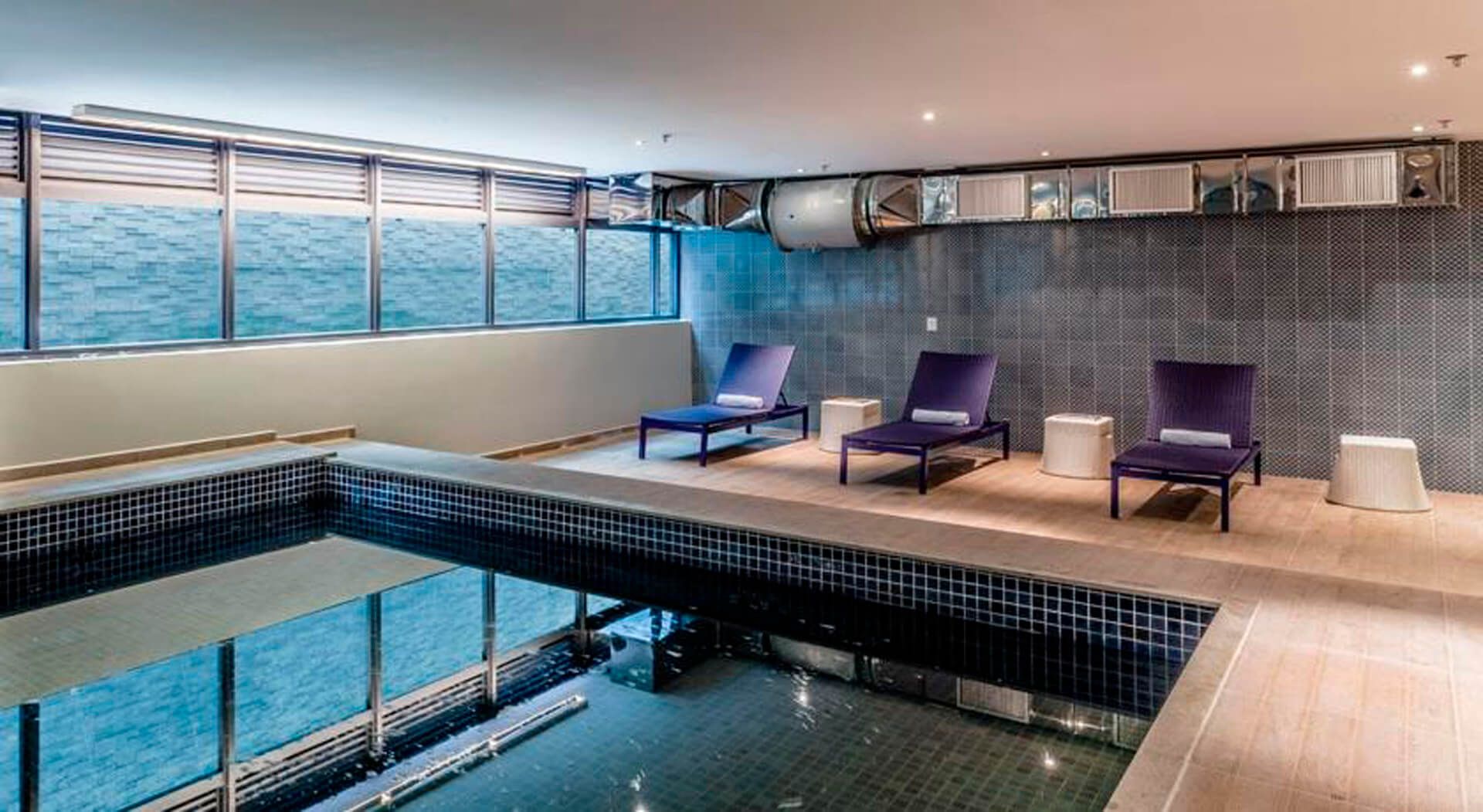 Uma grande piscina coberta com muitas cadeiras ao redor.