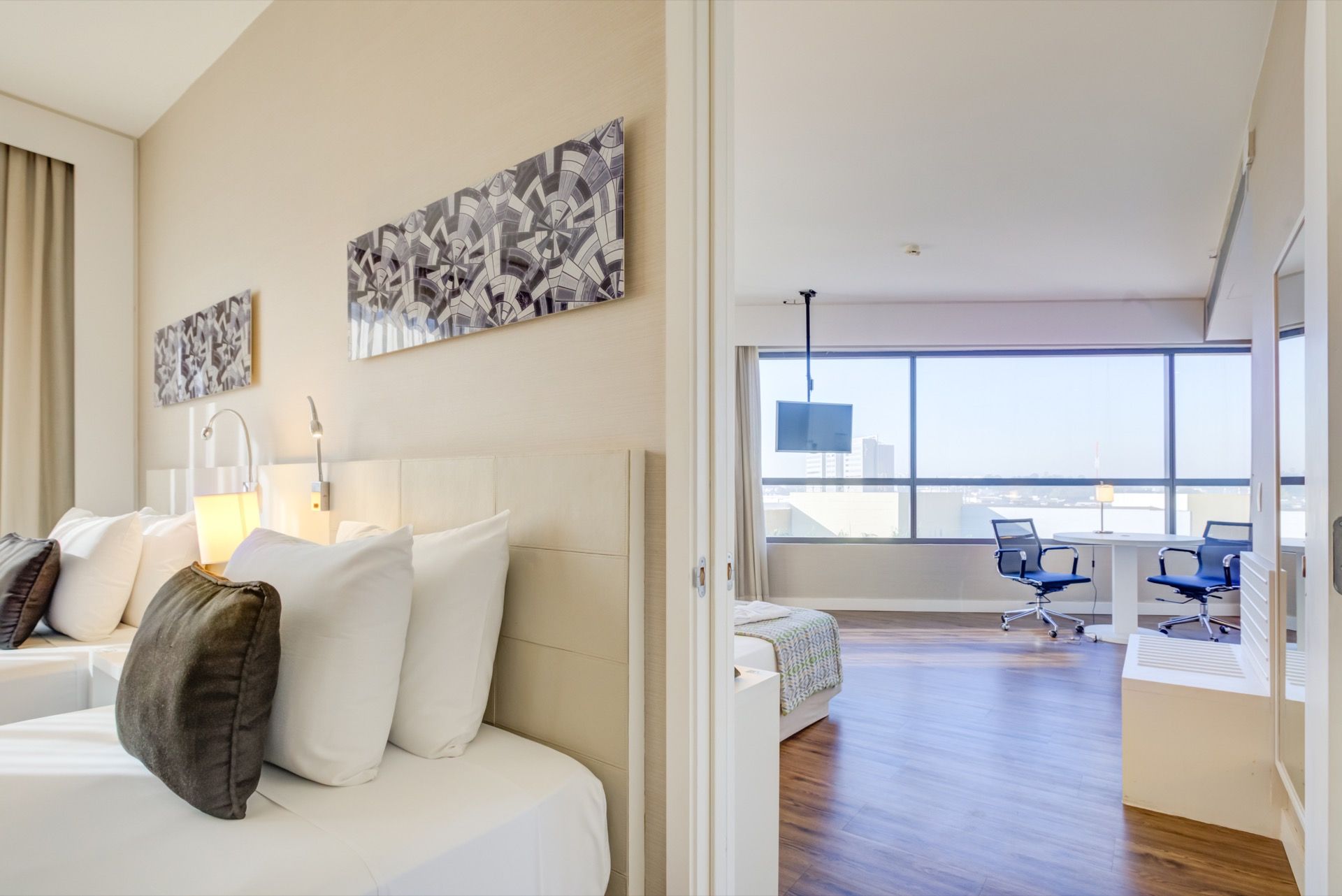 Um quarto de hotel com duas camas, uma escrivaninha e uma cadeira.