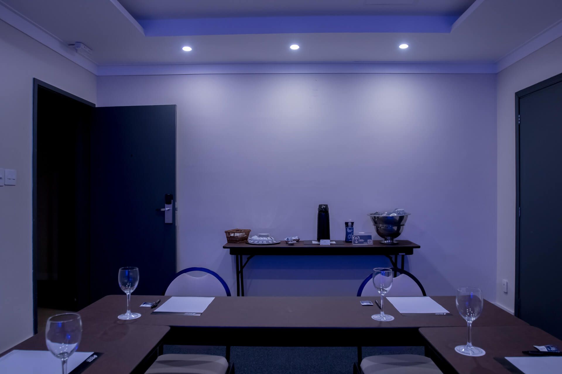 Uma sala de conferências com uma mesa e cadeiras preparadas para uma reunião.