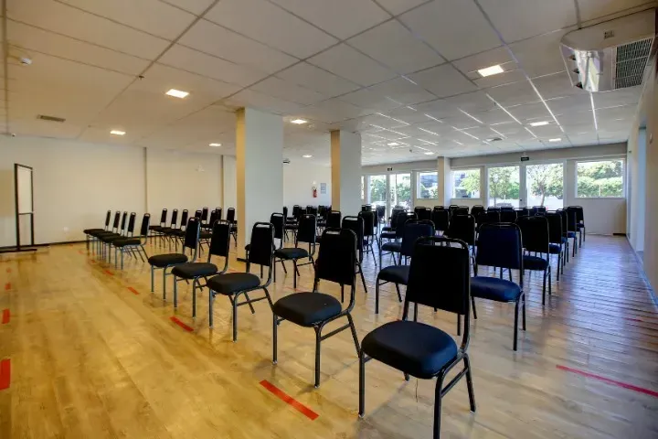 Uma sala de conferências com uma longa mesa de madeira e cadeiras.