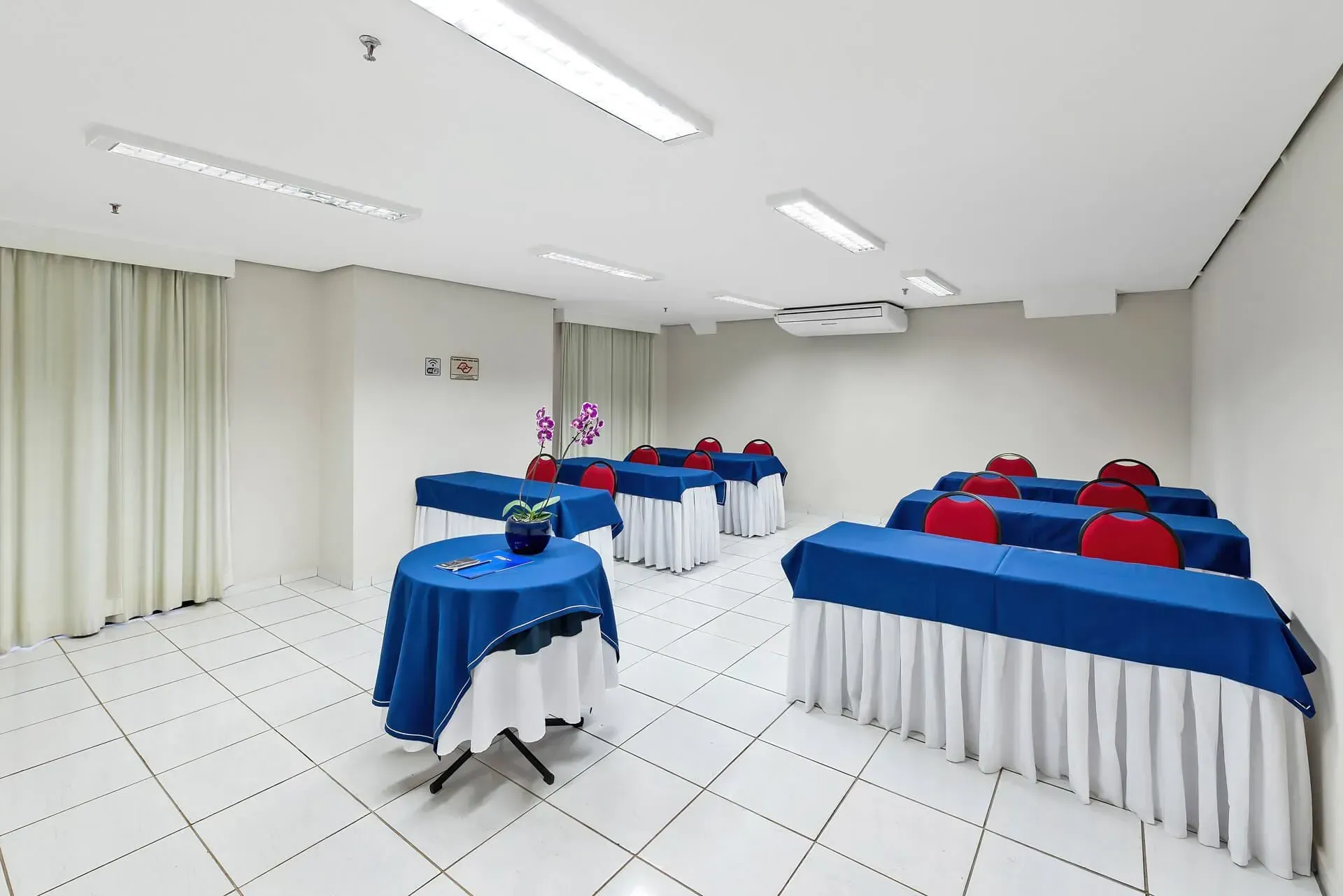 Uma sala de conferências com uma longa mesa de madeira e cadeiras.