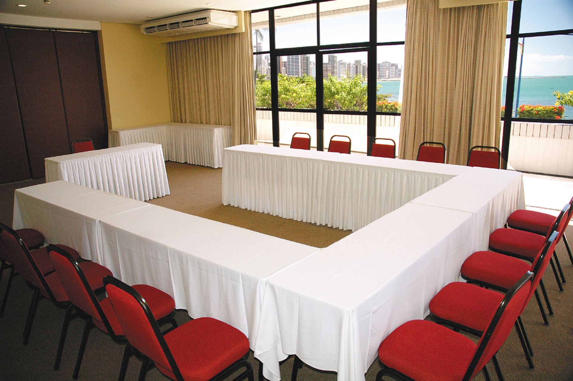 Uma sala de conferências com mesas e cadeiras e vista para o oceano