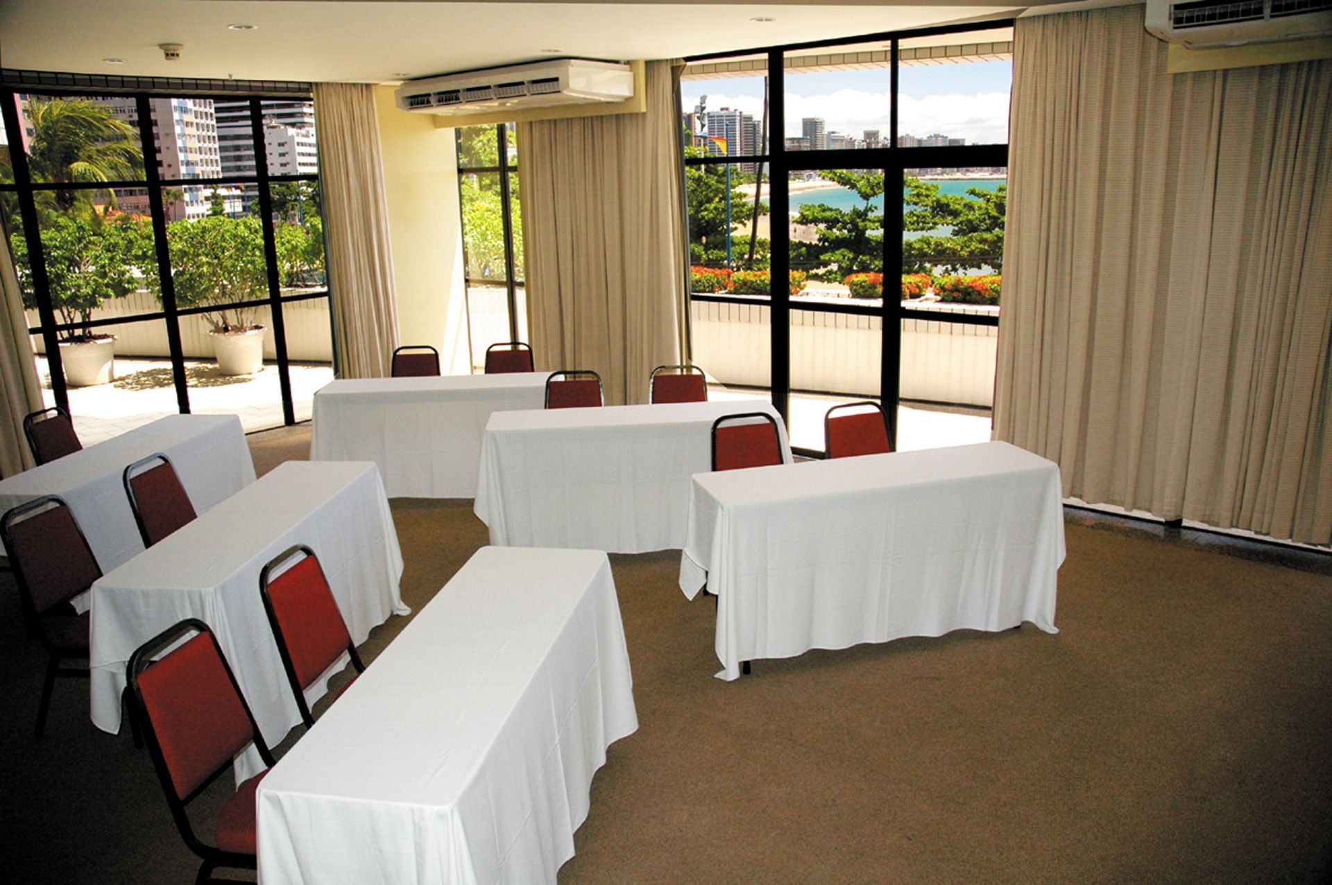 Uma sala com mesas e cadeiras e uma grande janela