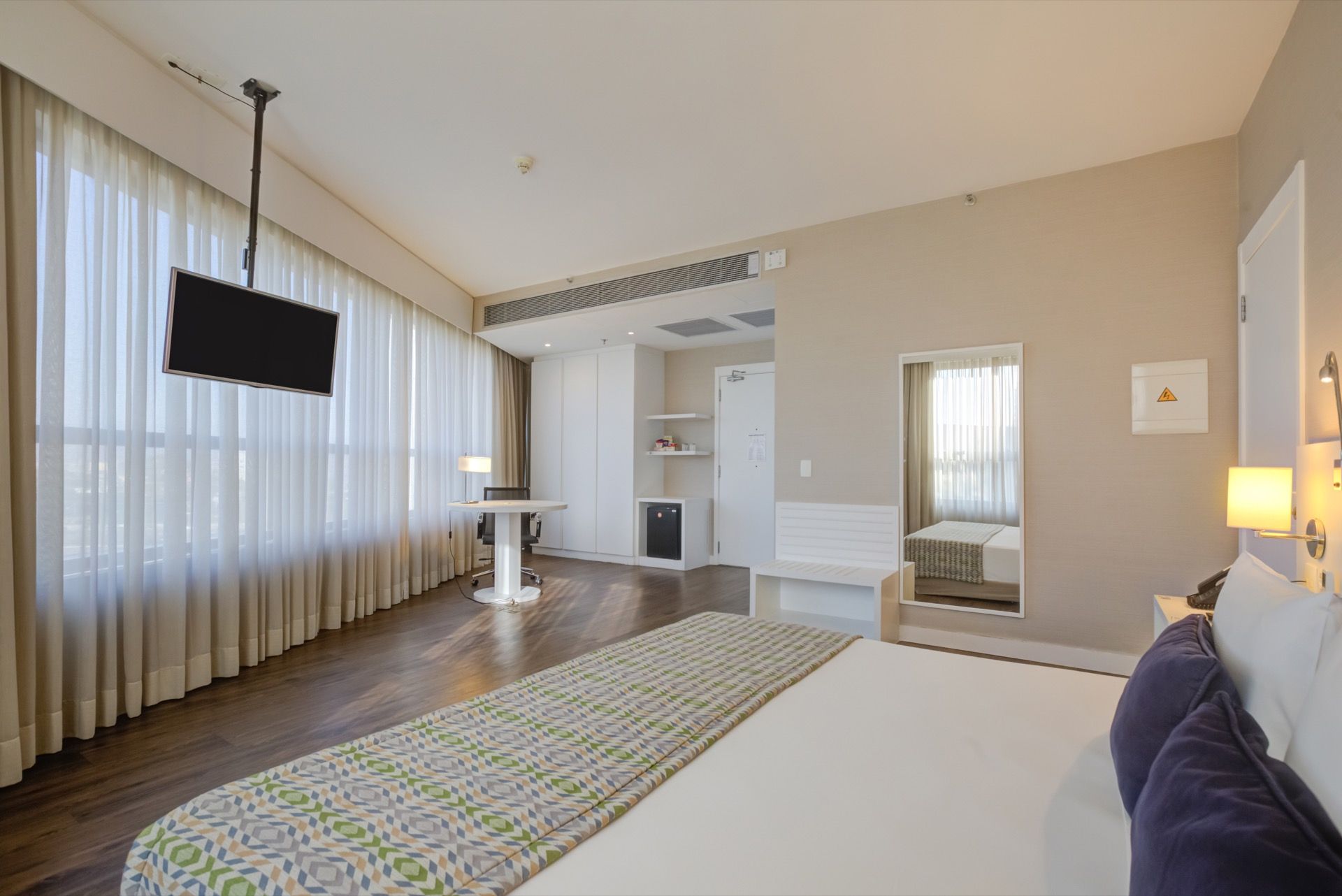 Um quarto de hotel com duas camas, uma escrivaninha e uma cadeira.