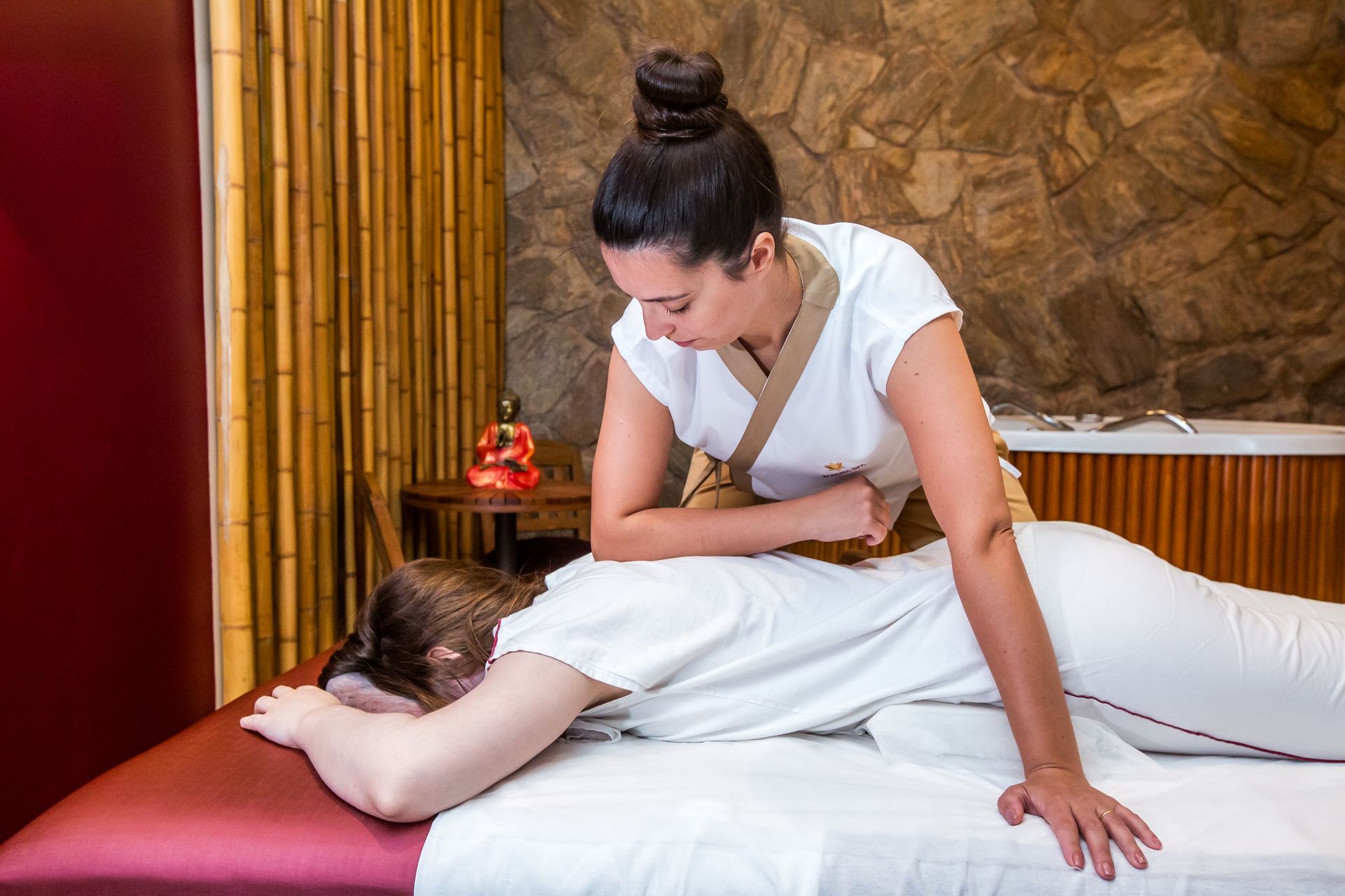 Uma mulher está fazendo uma massagem em outra mulher em um spa.