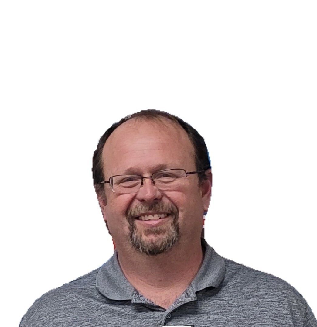 Smiling man with glasses and a gray polo shirt against a white background