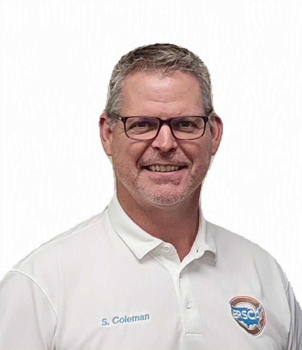 Portrait of a smiling man in a white polo shirt with glasses against a plain background.