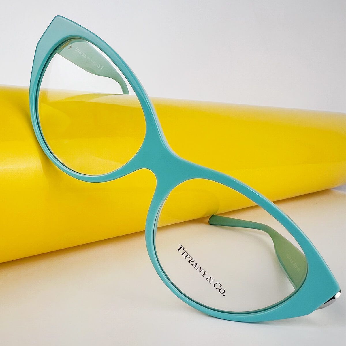Un paio di occhiali tiffany & co. appoggiati su uno sfondo giallo