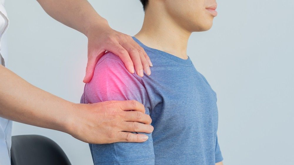 A Man is Getting His Shoulder Examined — Mark O'Brien Chiropractic in West End, QLD