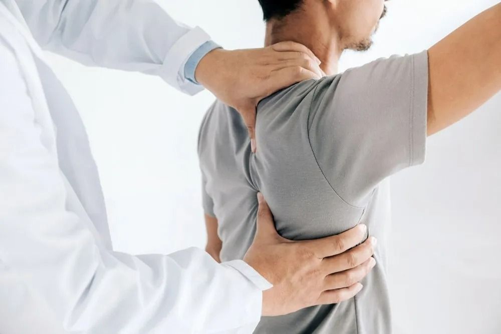 A Doctor is Examining the Back of a Patient 's Shoulder ā Mark O'Brien Chiropractic in West End, QLD