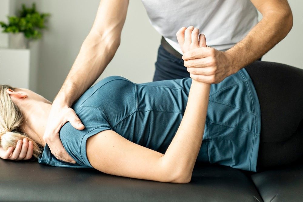 A Man is Giving a Woman a Massage — Mark O'Brien Chiropractic in West End, QLD