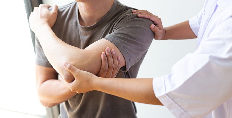 A Man is Getting His Arm Examined by a Doctor — Mark O'Brien Chiropractic in West End, QLD