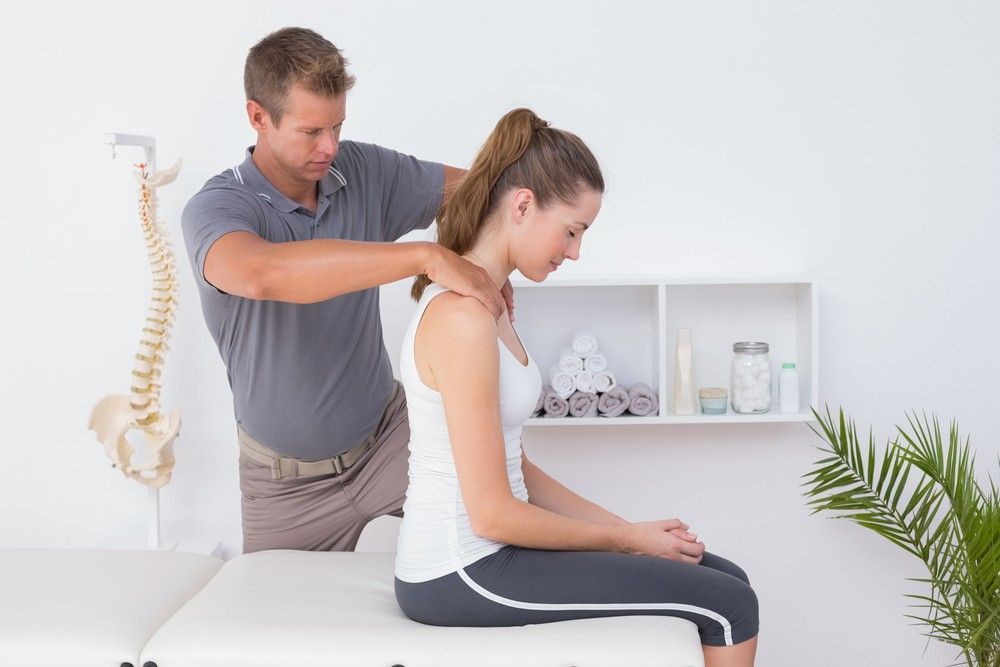 A Man is Giving a Woman a Massage on Her Neck — Mark O'Brien Chiropractic in West End, QLD