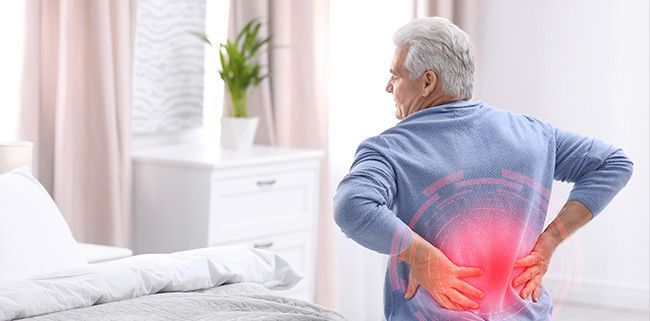 An older man experiences back pain.