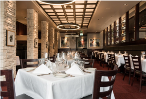 A large dining room with tables and chairs set for dinner