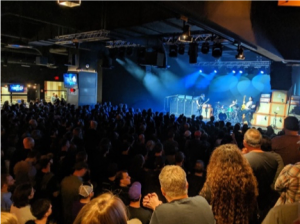 A crowd of people watching a band on stage