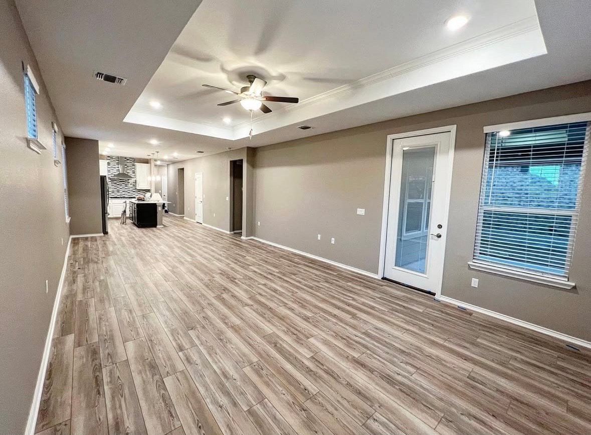 A kitchen with white cabinets , stainless steel appliances and a large island.