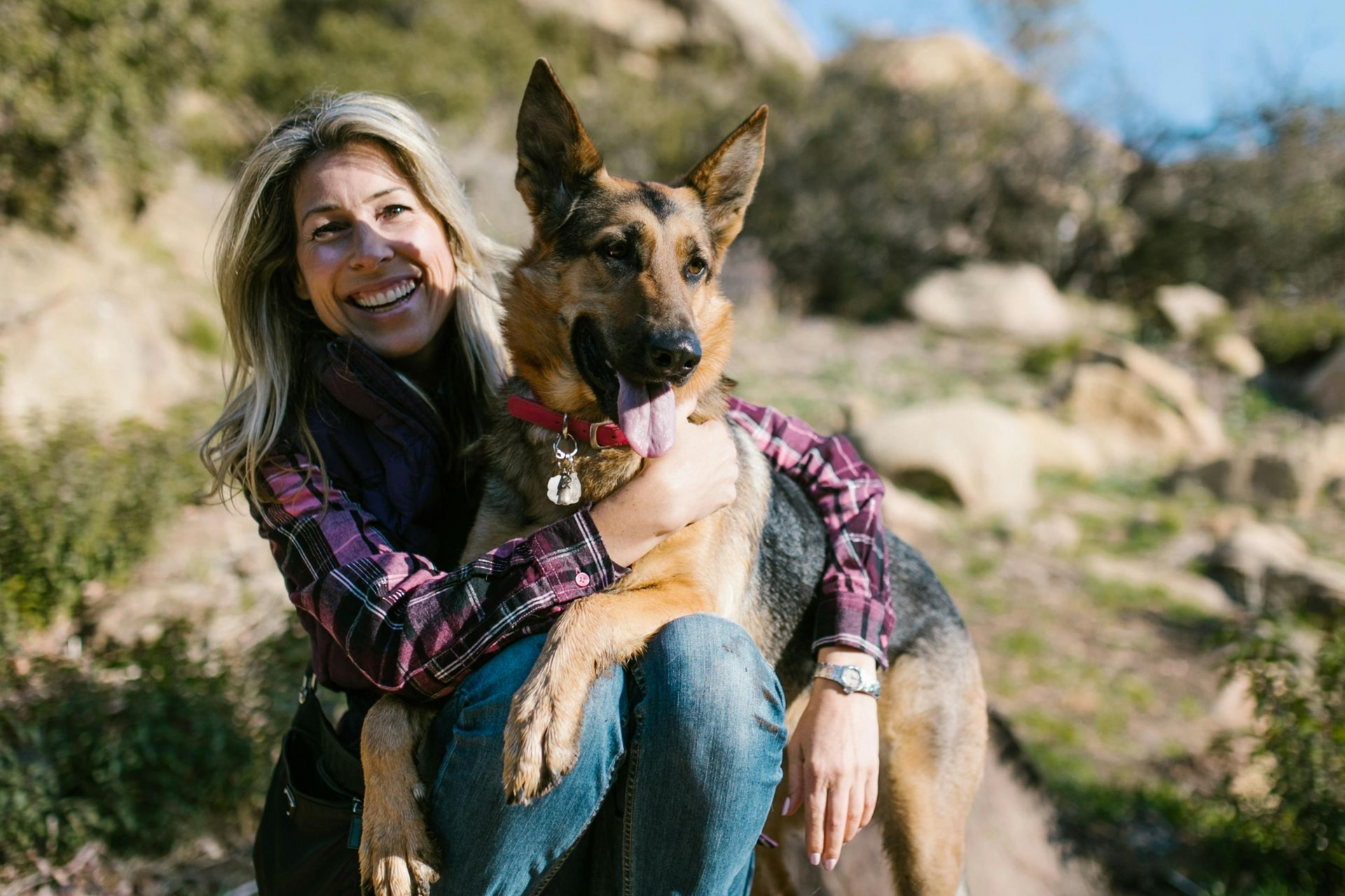 A woman and her German Shepherd dog hanging out after their long walk together in nature.