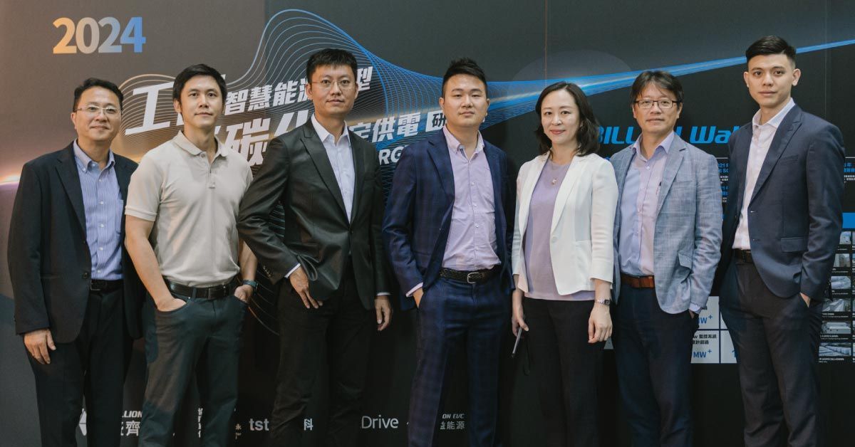 七個人正在合照。他們身著商務正裝,站在會議背景板前。