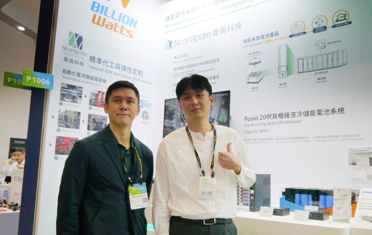 兩個男人在展位前展示訊息。其中一個豎起了大拇指。