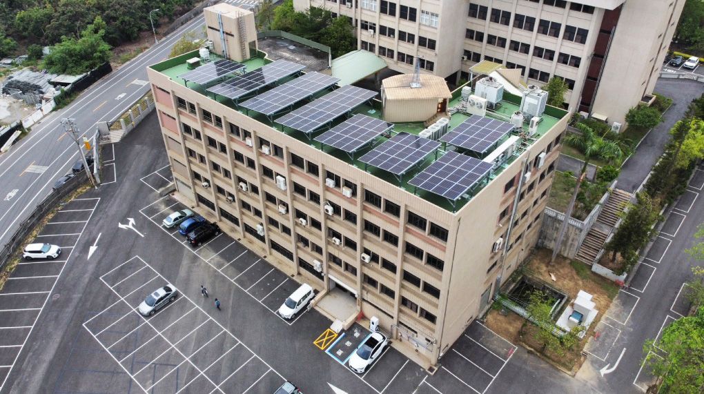 屋頂裝有太陽能電池板的建築物，周圍環繞著停車場和道路。