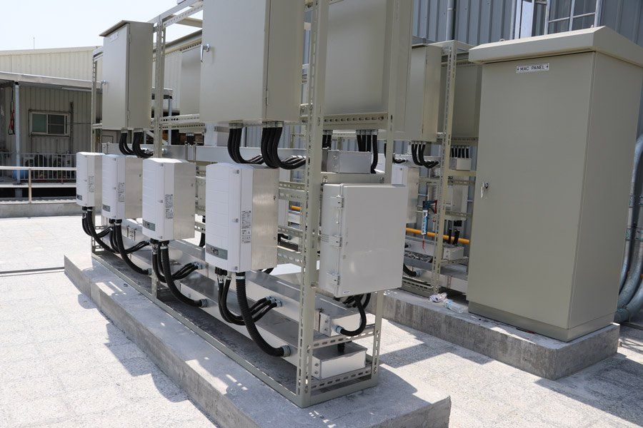 電氣設備、米色盒子和電線，放置在混凝土墊上，很可能是在室外。