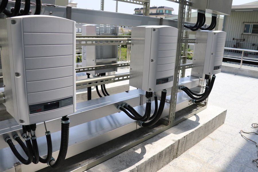 安裝在屋頂平台上的太陽能逆變器透過黑色電纜連接。