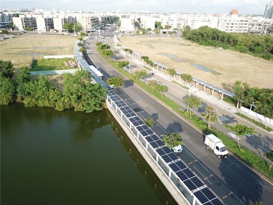 城市環境中的道路、太陽能板、湖泊和建築物的鳥瞰圖。