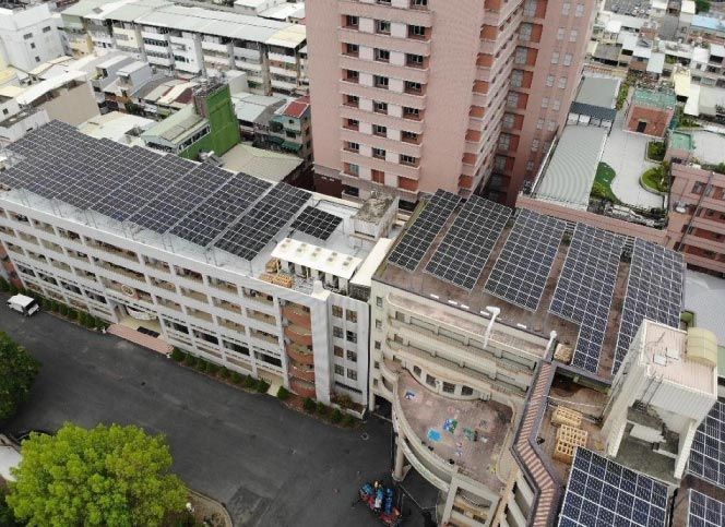 城市地區一棟多層建築的屋頂太陽能板；可見鄰近建築物。