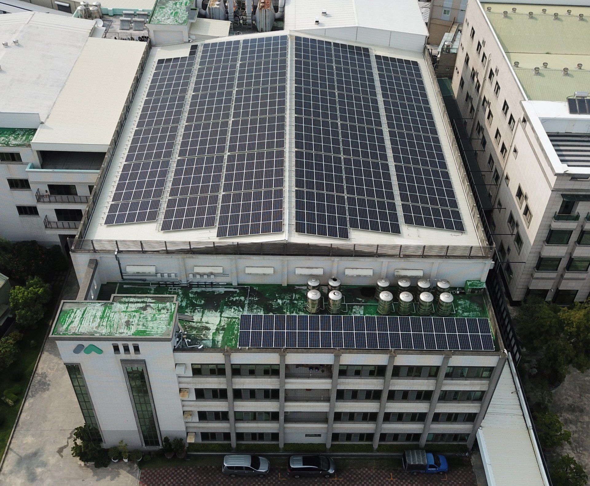 工廠屋頂覆蓋著太陽能電池板。這是一棟多層工業建築，屋頂平坦。