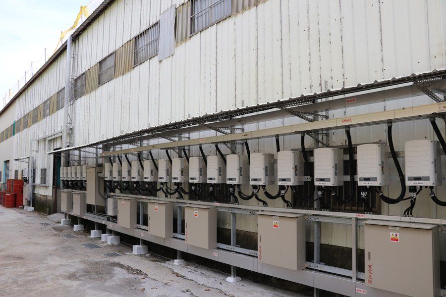 太陽能逆變器安裝在建築物側面的結構上，為工業設施供電。