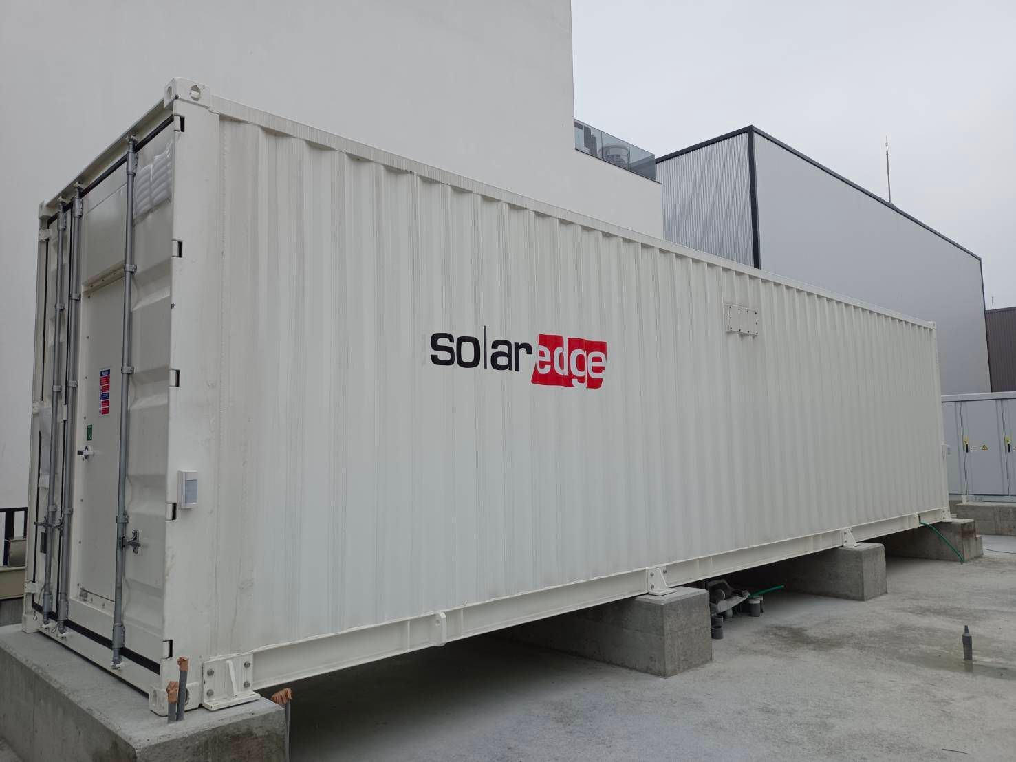 戶外，混凝土塊上放著標示「solar edge」的白色容器。