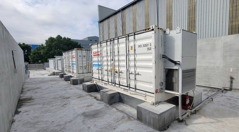 建築物旁邊，幾個白色貨櫃放在混凝土塊上。