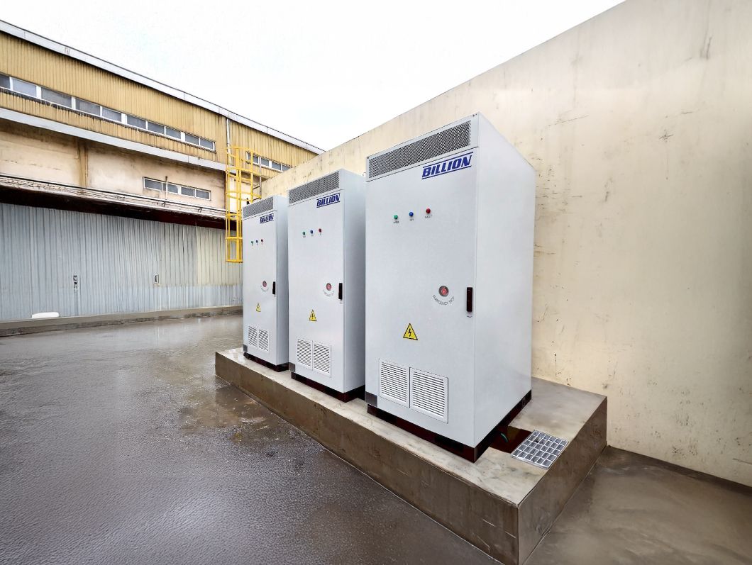 室外牆邊水泥地上放著三個白色電箱。