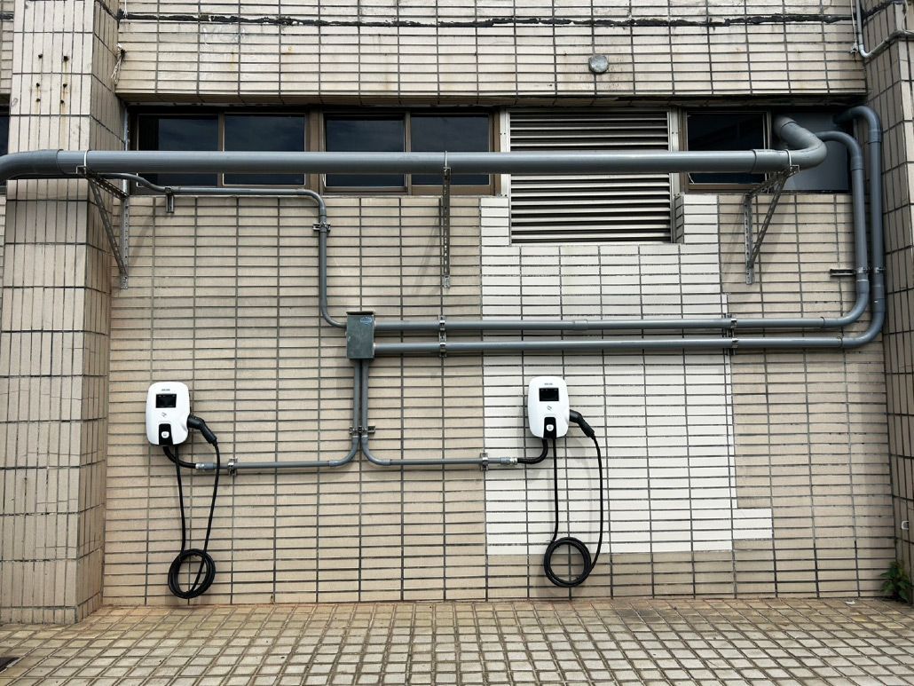 兩座電動車充電站安裝在磚砌建築物上，並配有灰色導管。