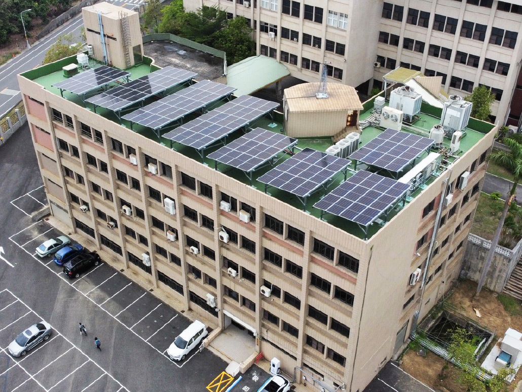 屋頂裝有太陽能板的建築，前面是停車場。