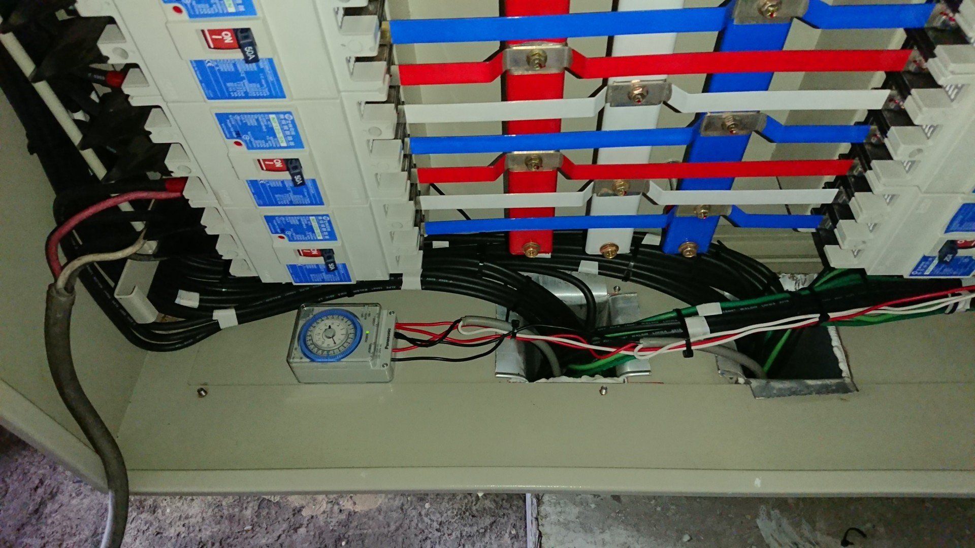 配電盤，內有斷路器、電線及母線。電線顏色分別為紅色、藍色和白色。