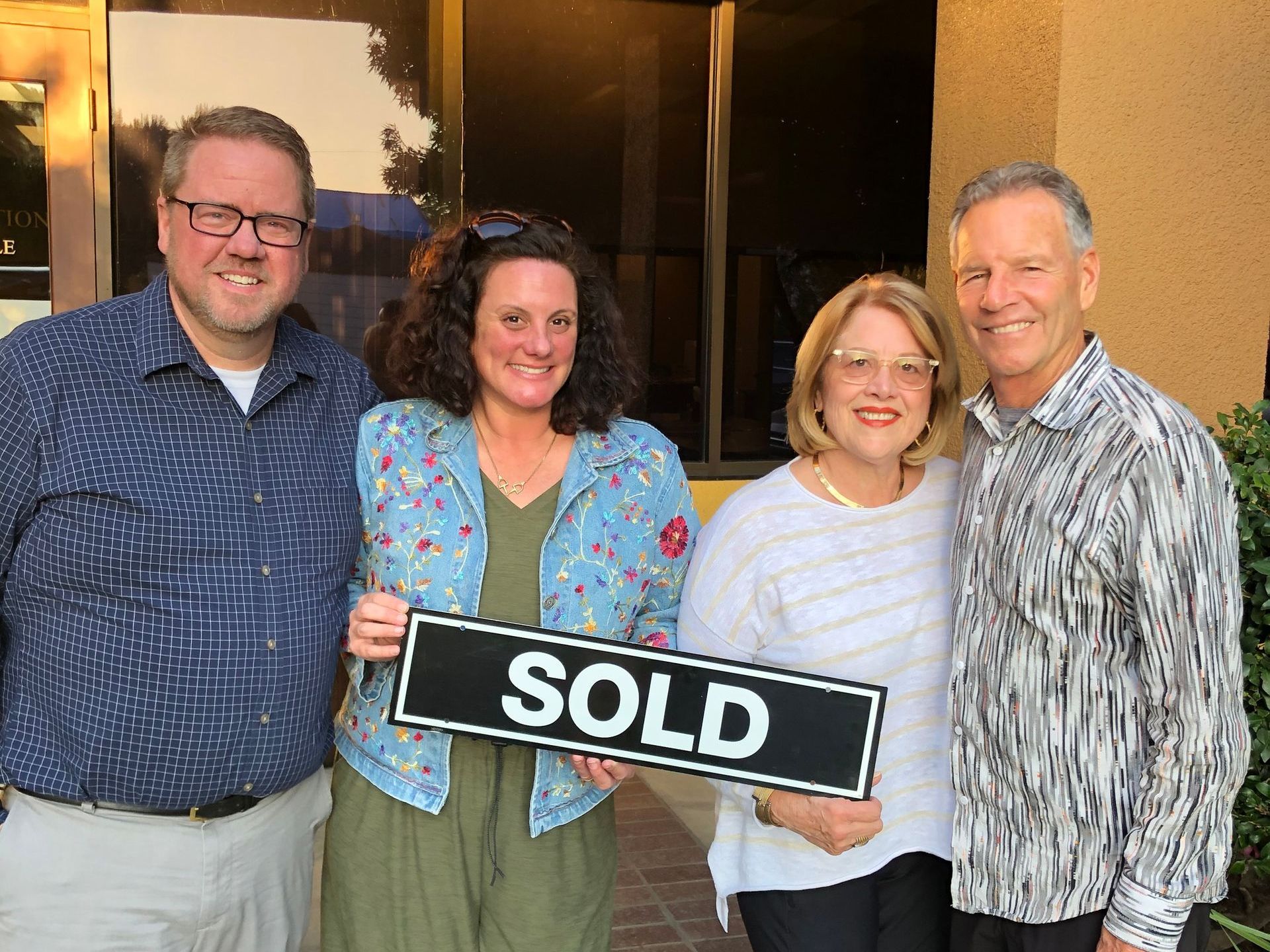 Donna and Barney with a husband and wife home sellers holding a sold sign