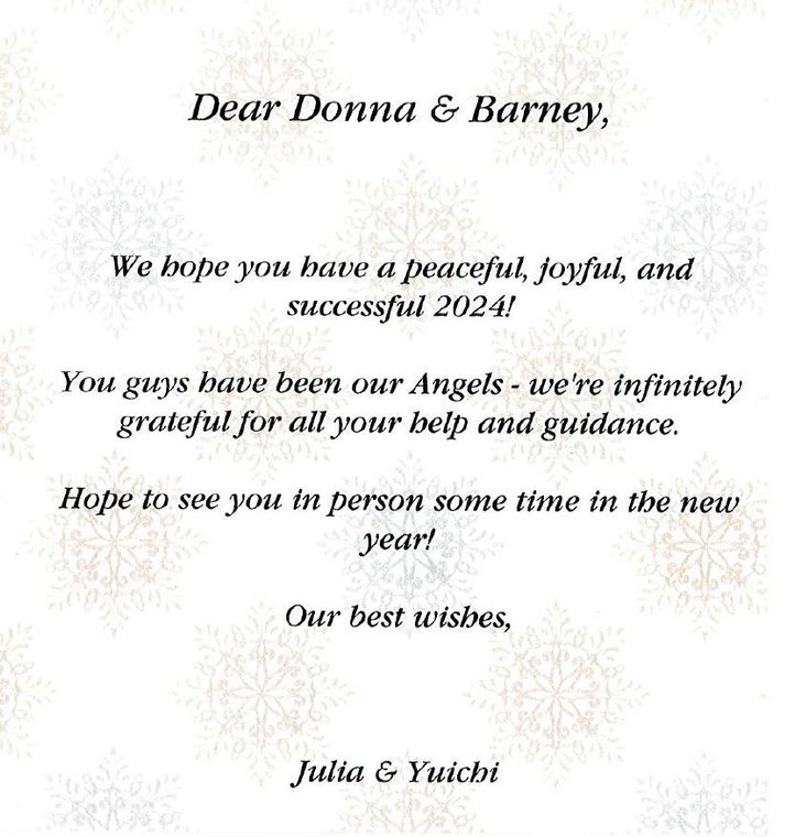 Holiday greeting card with cursive text on a pale snowflake background, signed Julia & Yuichi