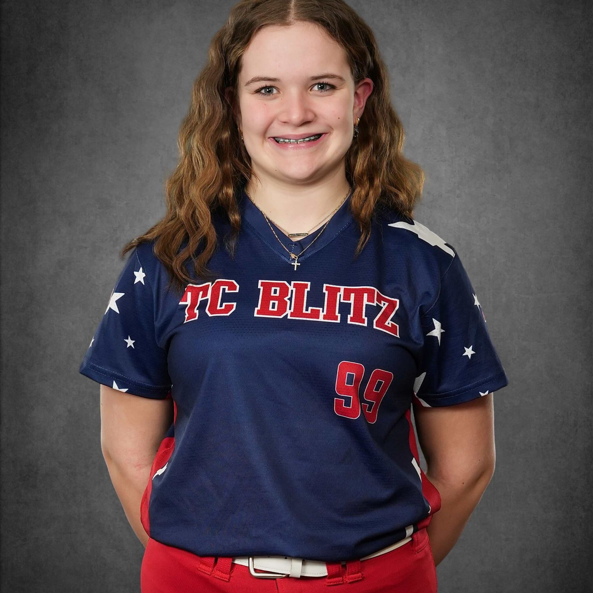 Portrait of a smiling athlete in a navy TC BLITZ jersey against a gray backdrop