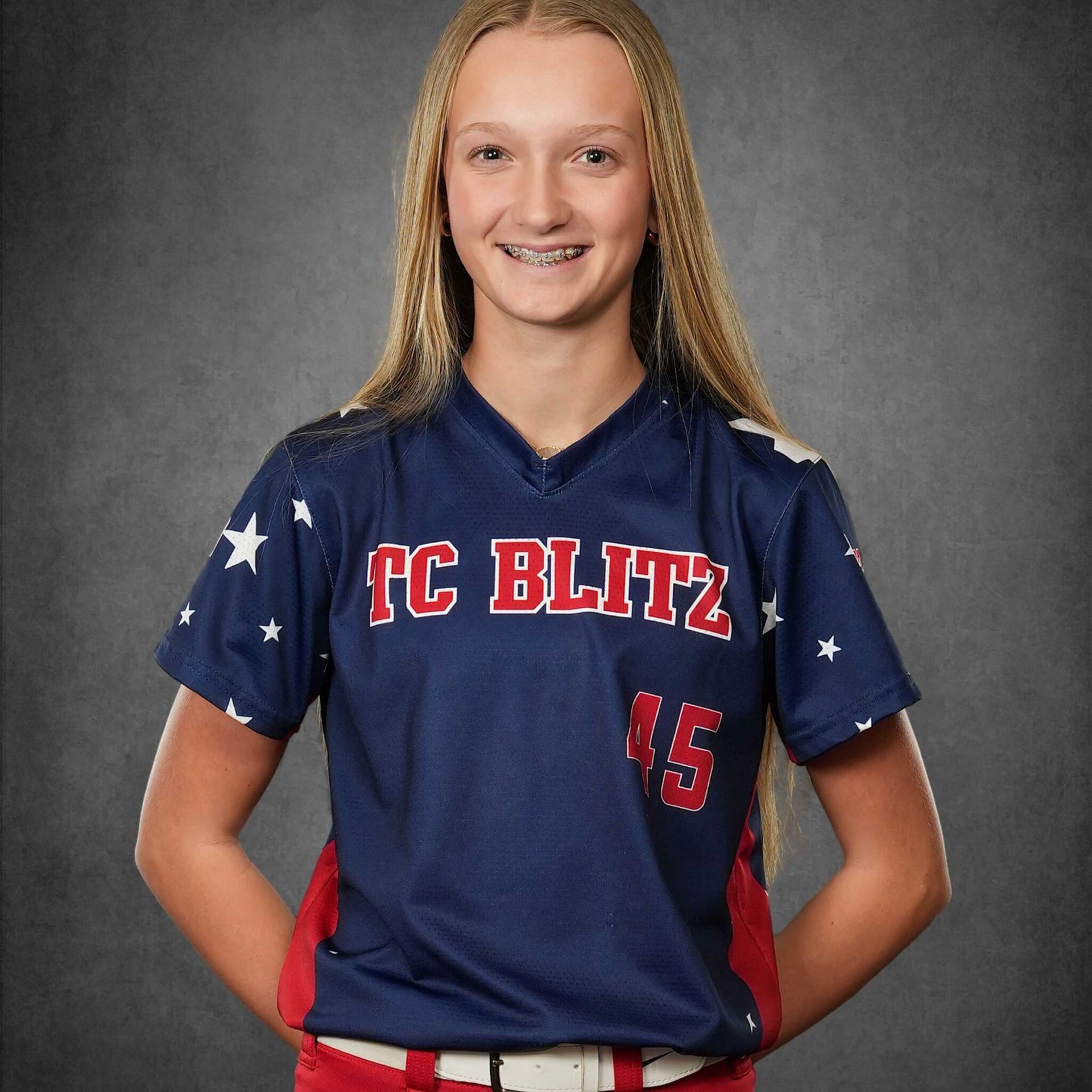 Smiling athlete in navy and red TC Blitz jersey against a gray studio backdrop