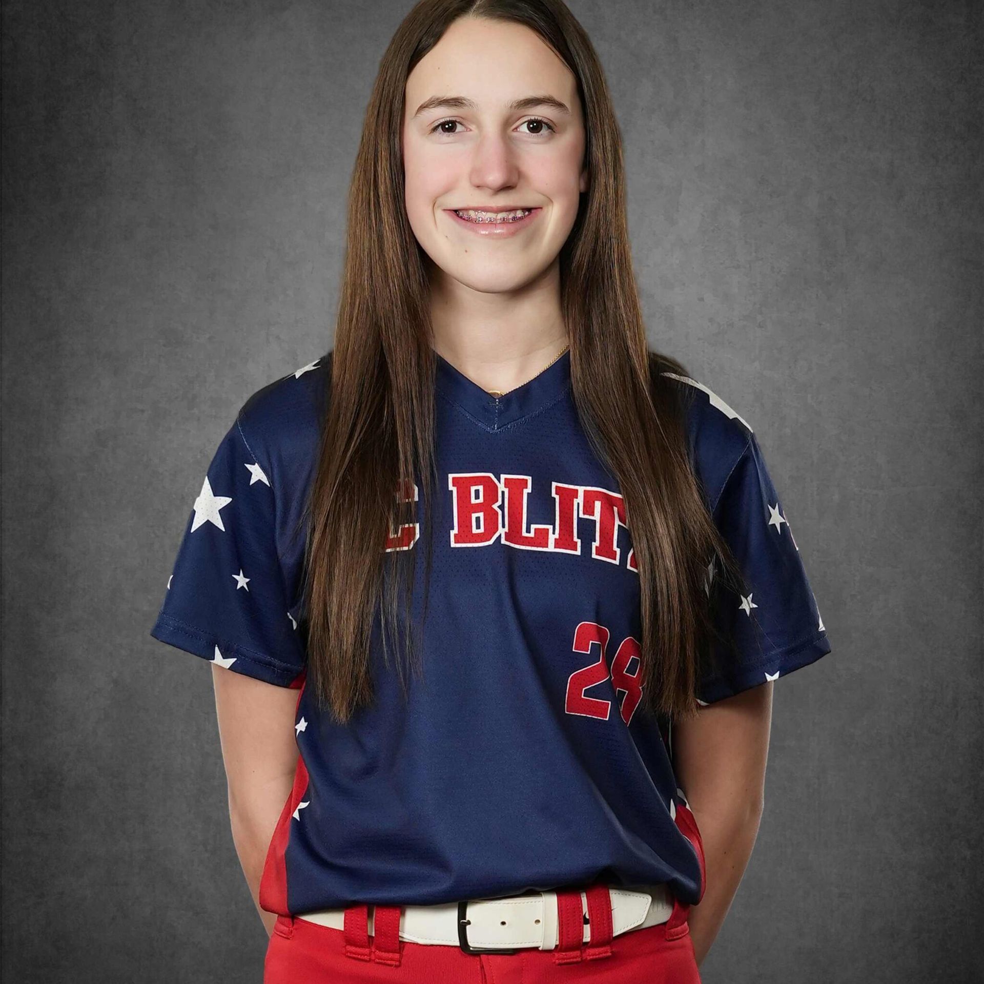 Portrait of a softball player in a navy jersey with red lettering and number 24 on a gray background