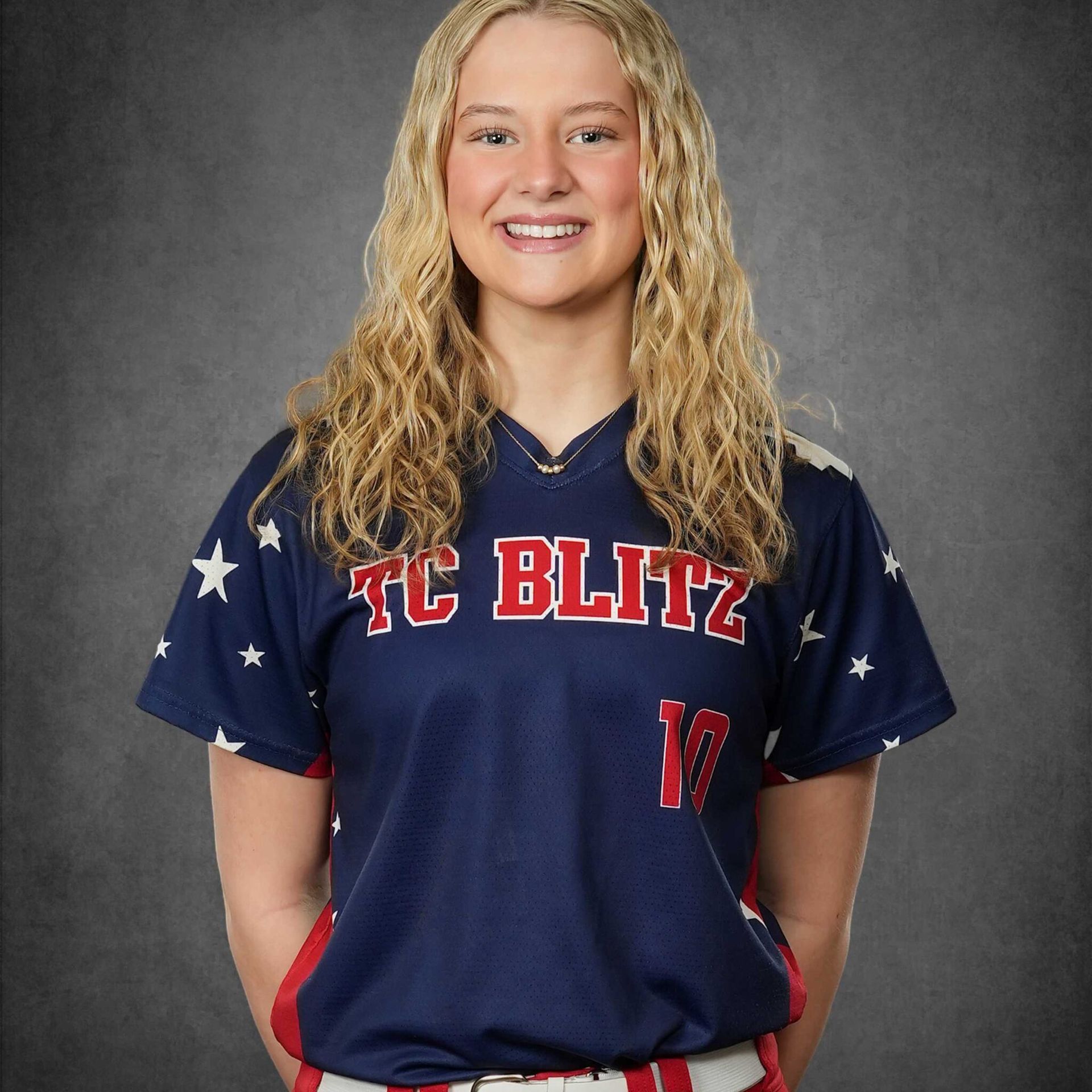 Smiling athlete in a navy TC Blitz jersey with red-and-white stars against a gray backdrop